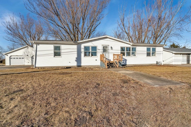 view of front facade featuring an outbuilding, a garage, and a front lawn