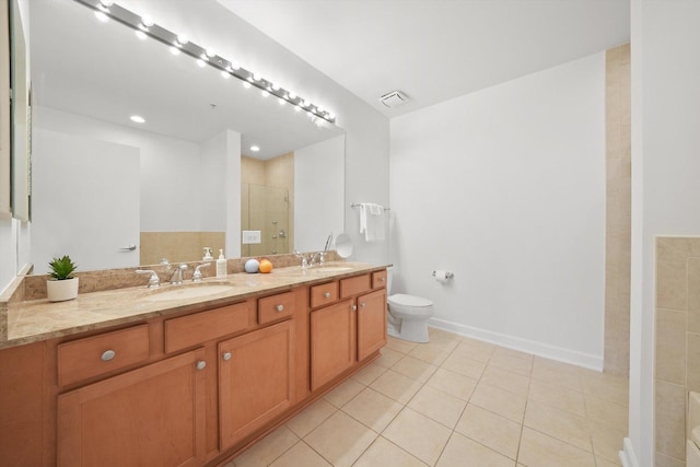 full bath featuring double vanity, toilet, a sink, a shower stall, and tile patterned flooring