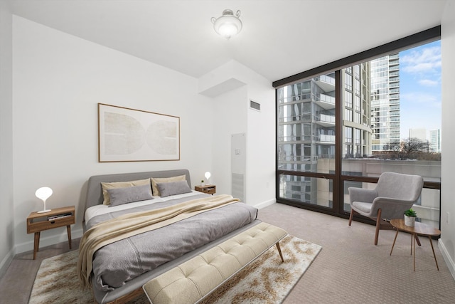 bedroom featuring expansive windows, carpet, visible vents, and baseboards