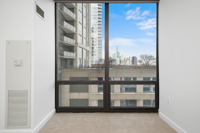 interior space featuring baseboards, a view of city, and visible vents