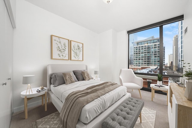 bedroom featuring light colored carpet, a city view, visible vents, and baseboards