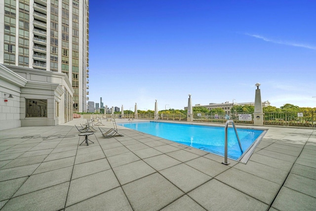 pool with a patio and fence