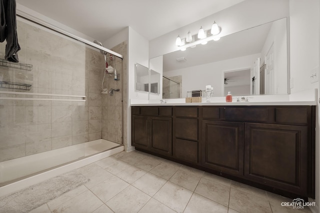 bathroom featuring vanity, a tile shower, and tile patterned floors