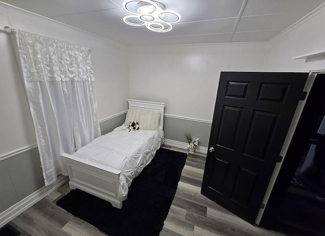 bedroom featuring wood-type flooring and ornamental molding