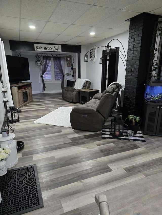 living room featuring a drop ceiling and hardwood / wood-style flooring