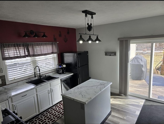 kitchen with sink, dishwasher, white cabinetry, hanging light fixtures, and a center island