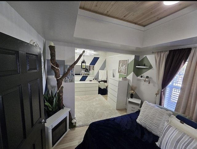 bedroom with light wood-type flooring and wood ceiling