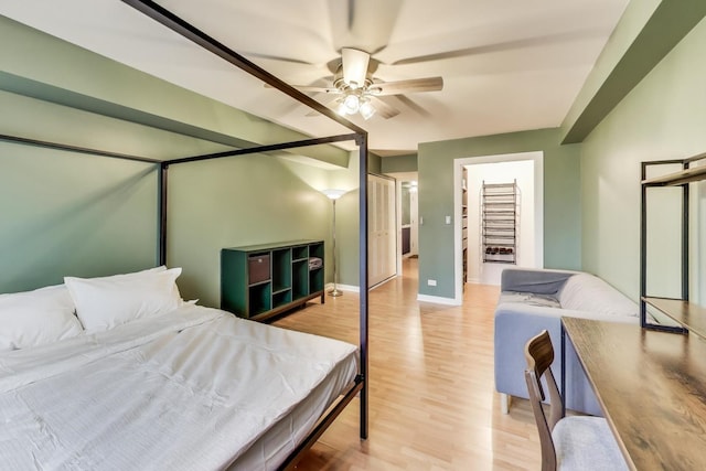 bedroom featuring light wood finished floors, ceiling fan, and baseboards