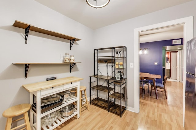 office space featuring light wood-style flooring, visible vents, and baseboards