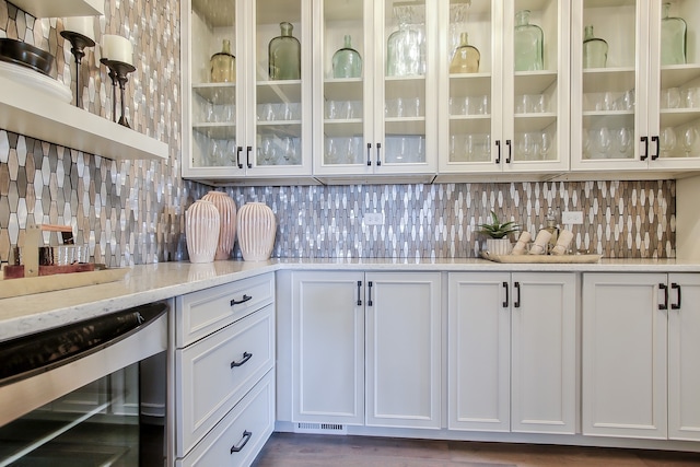 bar featuring white cabinetry, wine cooler, and light stone counters