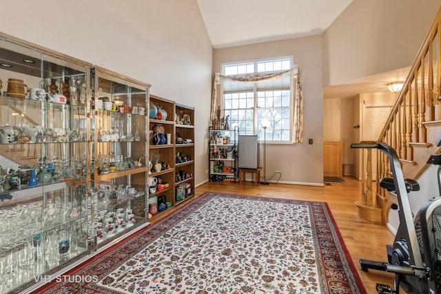 interior space with vaulted ceiling, wood finished floors, and baseboards