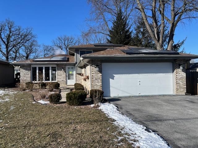 view of front of home featuring a garage and solar panels