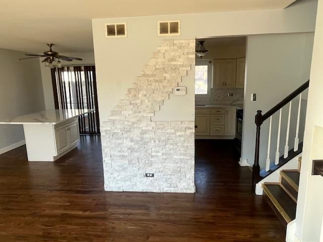 interior space featuring backsplash, white cabinets, dark hardwood / wood-style flooring, a center island, and ceiling fan