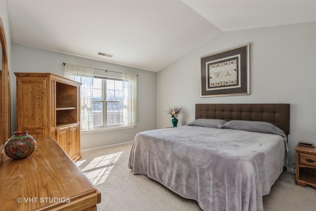 bedroom with light carpet, vaulted ceiling, visible vents, and baseboards