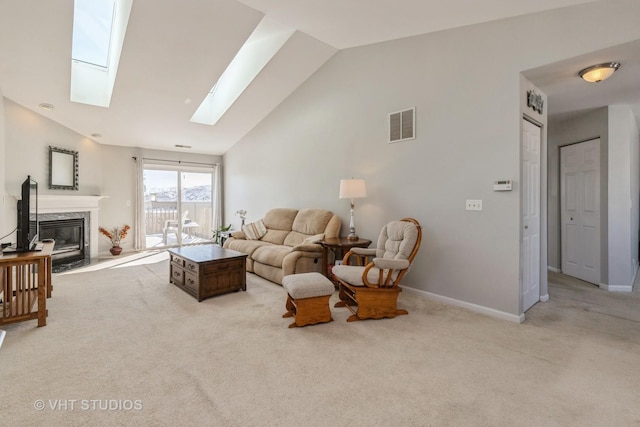 living area with light carpet, a skylight, visible vents, baseboards, and a high end fireplace