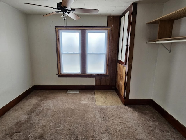 spare room with ceiling fan and carpet