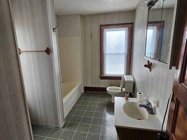 bathroom with wooden walls, vanity, a tub to relax in, tile patterned floors, and toilet