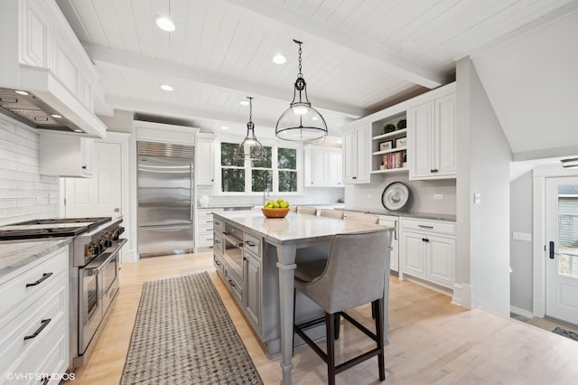 kitchen featuring high end appliances, a center island, and white cabinets