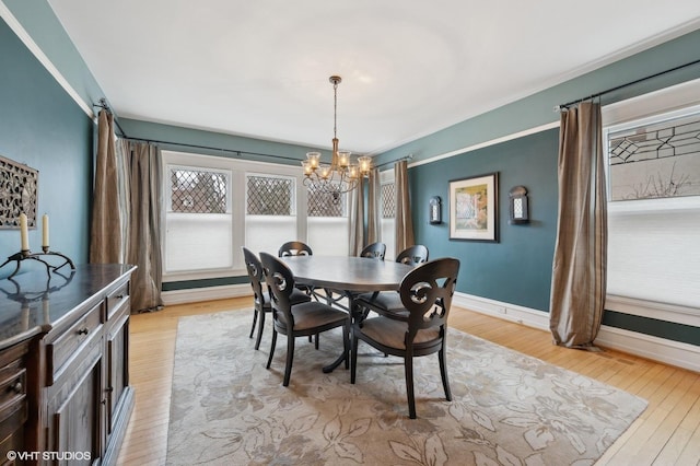 dining area with an inviting chandelier and light hardwood / wood-style floors