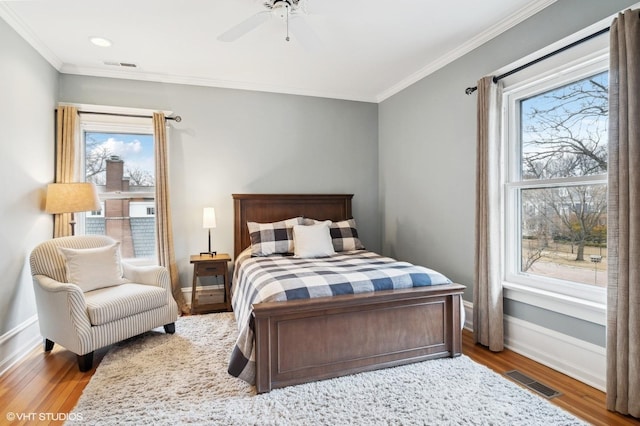 bedroom with hardwood / wood-style flooring, ceiling fan, and crown molding