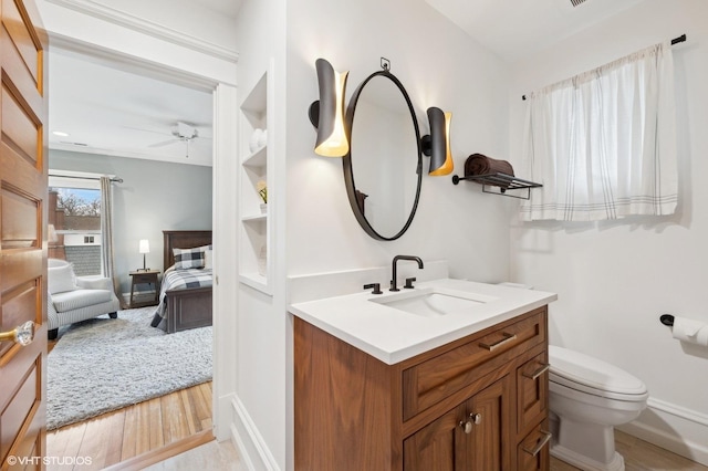 bathroom featuring hardwood / wood-style flooring, ceiling fan, vanity, and toilet