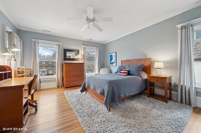 bedroom featuring light hardwood / wood-style flooring, ornamental molding, and ceiling fan