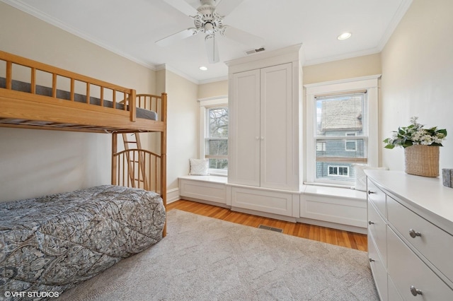 bedroom with multiple windows, crown molding, and light hardwood / wood-style floors