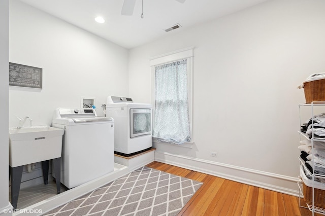 laundry area with ceiling fan, wood-type flooring, and washer and clothes dryer