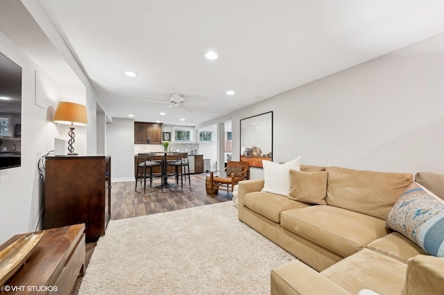 living room with ceiling fan and dark hardwood / wood-style flooring