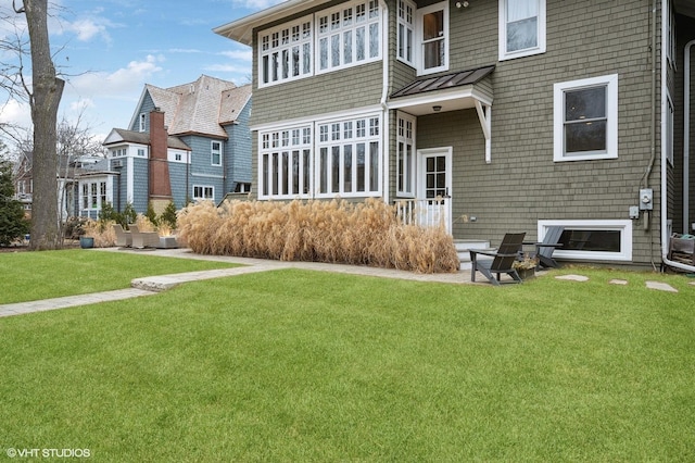 rear view of property featuring a lawn