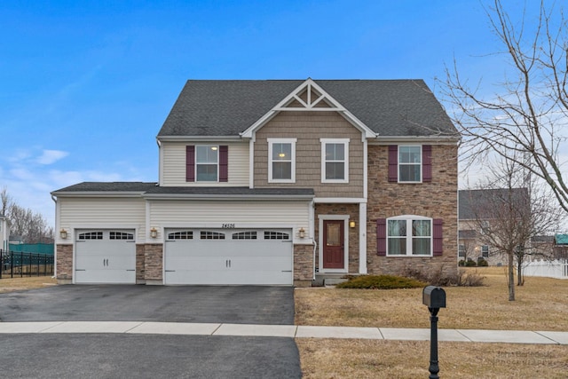 craftsman house with stone siding, driveway, a garage, and fence