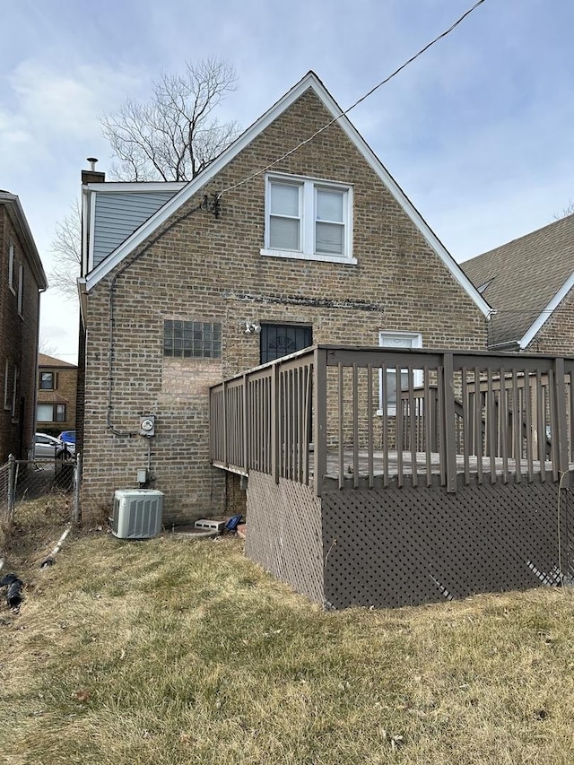 back of property with a deck, a yard, and central AC unit