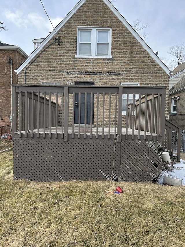 rear view of property with a wooden deck and a yard