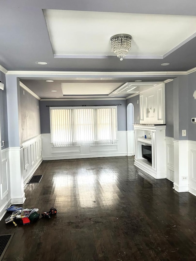 unfurnished living room with ornamental molding, dark hardwood / wood-style flooring, and a notable chandelier