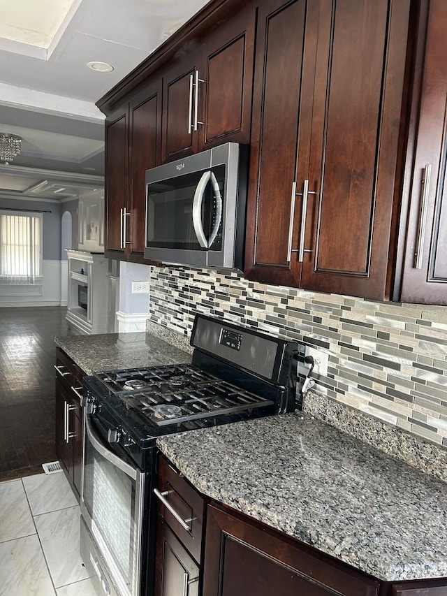 kitchen featuring backsplash, appliances with stainless steel finishes, and dark stone counters