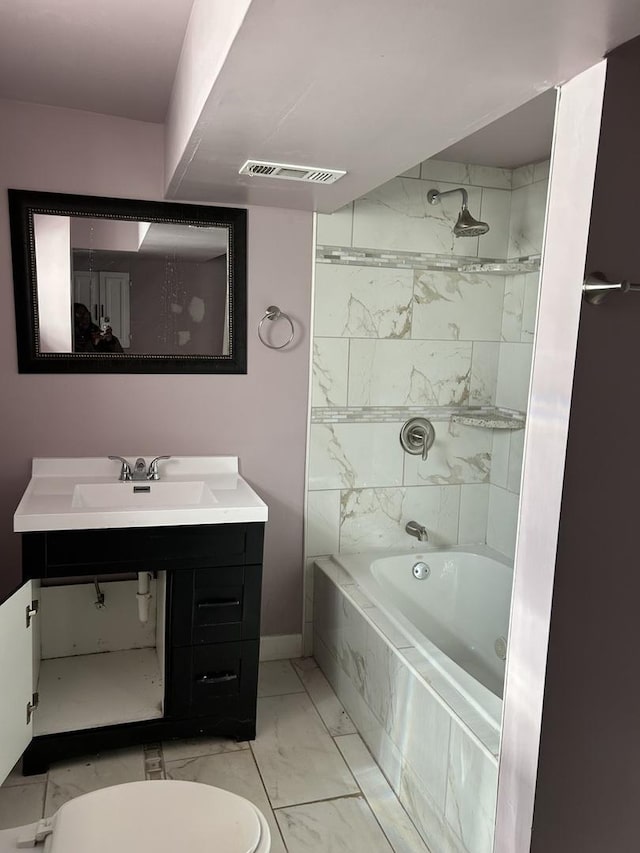 full bathroom with sink, tiled shower / bath combo, and toilet