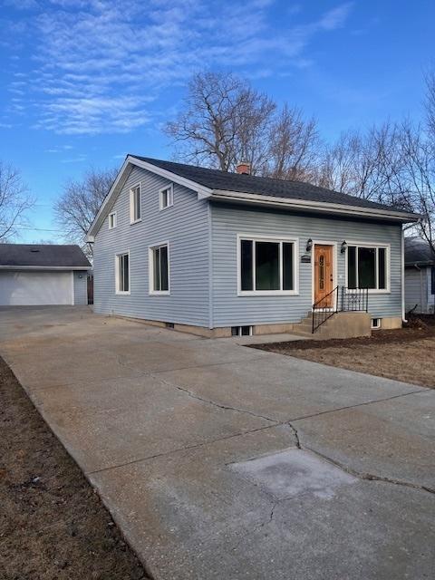 view of front facade featuring a garage and an outdoor structure