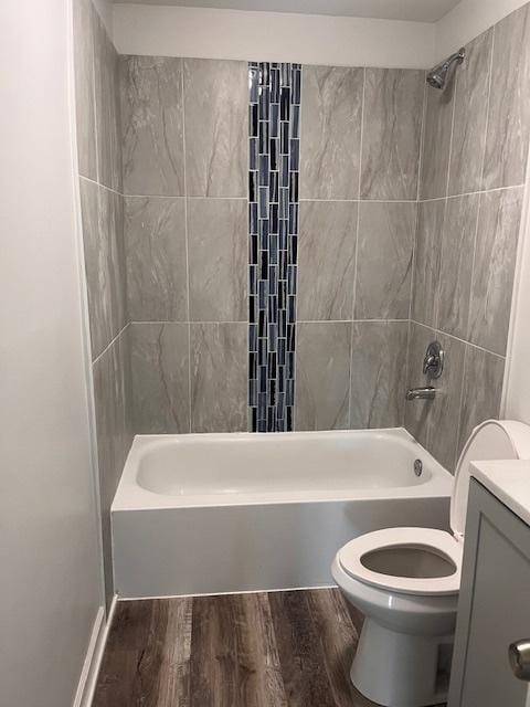 full bathroom with vanity, wood-type flooring, toilet, and tiled shower / bath