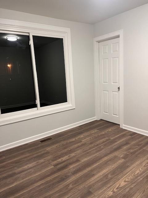 empty room with dark hardwood / wood-style floors