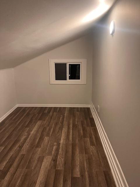 additional living space featuring dark hardwood / wood-style flooring and lofted ceiling