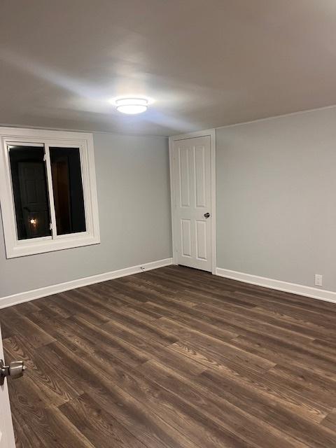 unfurnished room featuring dark hardwood / wood-style flooring