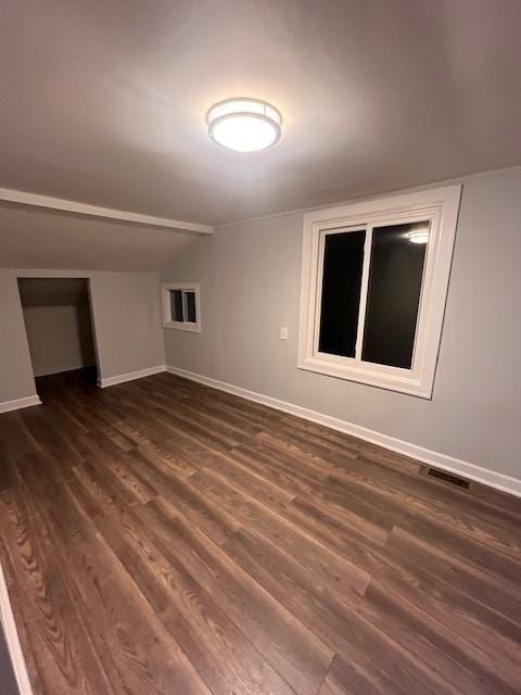 spare room with lofted ceiling and dark hardwood / wood-style flooring