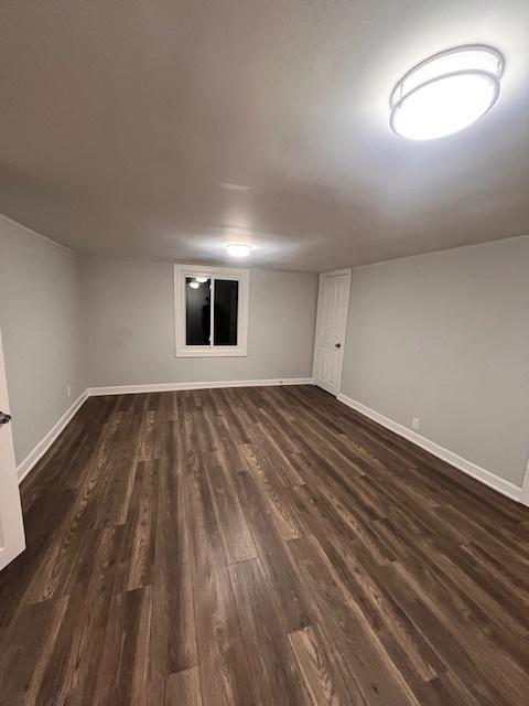 basement with dark hardwood / wood-style floors