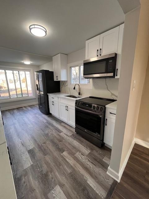 kitchen featuring sink, white cabinetry, stainless steel appliances, dark hardwood / wood-style floors, and decorative backsplash