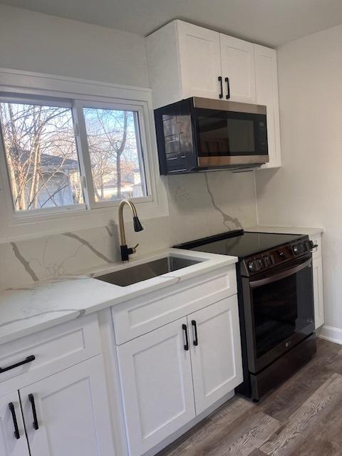 kitchen featuring tasteful backsplash, stainless steel appliances, sink, and white cabinets