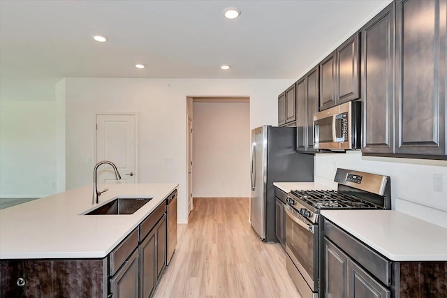 kitchen featuring sink, dark brown cabinets, light hardwood / wood-style flooring, and stainless steel appliances