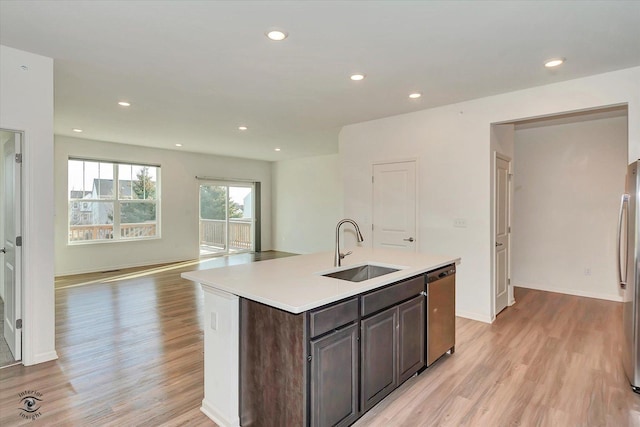 kitchen featuring sink, light hardwood / wood-style flooring, a kitchen island with sink, dark brown cabinets, and stainless steel appliances