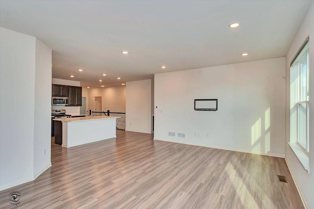 unfurnished living room featuring sink and light wood-type flooring