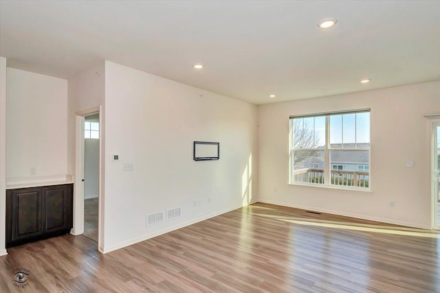 spare room with a wealth of natural light and light hardwood / wood-style flooring