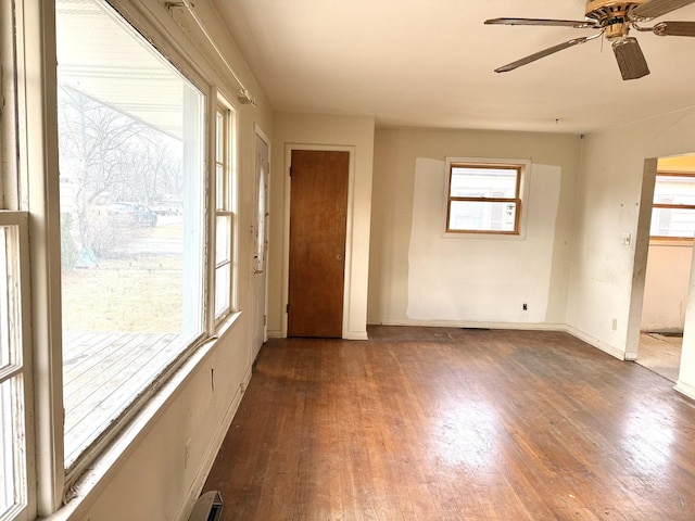 empty room with ceiling fan and dark hardwood / wood-style flooring